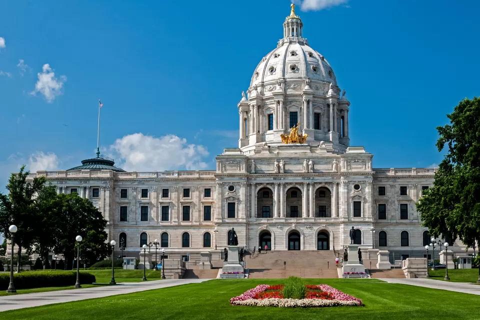 Minnesota state capitol building with red flowers on green front lawn
